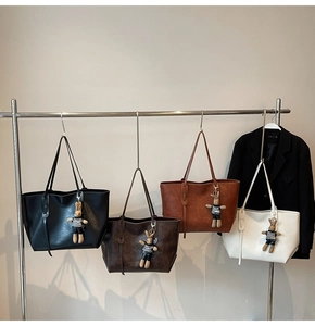 Detail view of stylish tote bags in four colors with cute rabbit charms and leather texture