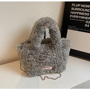 Detail of grey plush tote bag with furry texture and Keep Your Spirit Free label