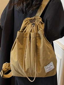 Mustard yellow drawstring backpack in waterproof nylon with minimalist brand label