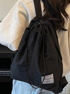 Minimalist black drawstring backpack with side pockets and light water-resistant fabric