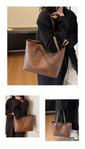 Detail view of brown leather tote bag with embossed text and polished metal hardware