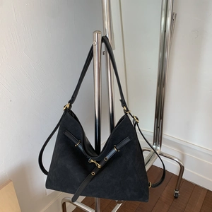 Detail of black large tote bag with suede texture, gold hardware and leather trim