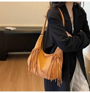 Détail du sac hobo en daim marron avec de longues franges et une boucle en métal sobre
