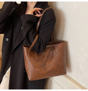 Detail of the high-capacity vintage brown leather tote bag with elegant shoulder straps
