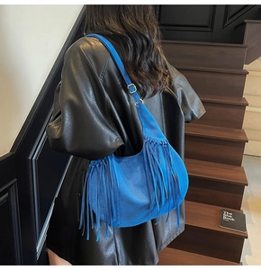 Détail du sac hobo en daim bleu avec longues franges et boucle en métal doré