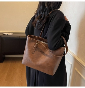Detail of caramel brown tote bag with leather texture and fashion bag lettering