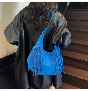 Détail du sac hobo en daim bleu roi avec de longues franges et des anneaux dorés