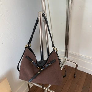Detail of vintage brown suede tote bag with black leather straps and gold metal eyelets