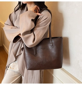 Deep brown tote bag with fashion bag NEW YORK text and natural leather texture on model