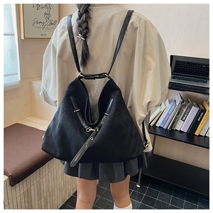 Detail view of large quilted black dual-use backpack with soft leather straps and texture