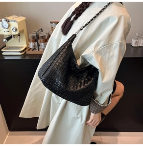 Détail du sac hobo en cuir tressé noir avec chaîne en métal argenté et bandoulière