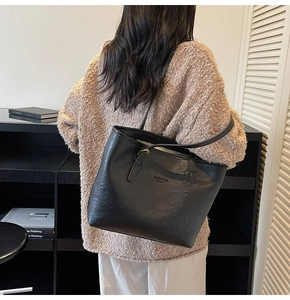 Close-up of black matte tote bag featuring embossed fashion bag NEW YORK lettering detail