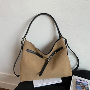 Detail of khaki suede Hobo bag with decorative black leather straps and gold metal ring