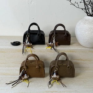 Boston mini handbags in four colors with cute bear charms on tiered marble display