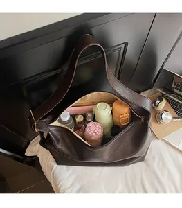 Detail view of large brown faux leather tote bag interior showing high storage capacity