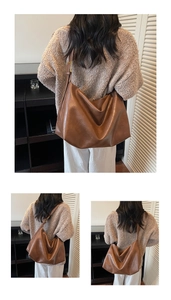 Detail of a brown large leather tote bag with smooth texture and adjustable strap