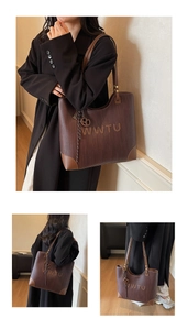 Detailed view of dark brown tote bag featuring woven texture and metallic WWTU ornament