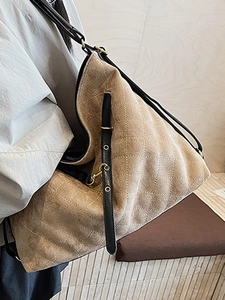 Quilted beige hobo shoulder bag with black straps and golden metal eyelets on model