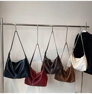 Five colors of large capacity faux leather tote bags hanging on a display rack
