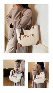 Detail of cream woven tote bag with brown leather trim and stylish decorative pendant