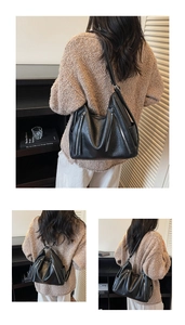Detail view of black PU leather shoulder bag showing pebbled texture and zipper accents