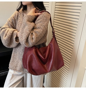 Detail view of the burgundy large tote bag with textured soft leather and golden hardware