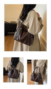 Detail of dark brown leather tote bag showing convertible straps and side pockets