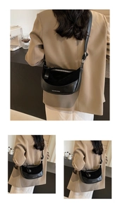 Dettaglio della borsa a mezzaluna nera in pelle patchwork con testo del logo bianco
