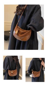 Dettaglio di una borsa hobo vintage marrone con testo fashion e tracolla regolabile