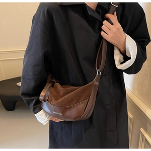 Dettaglio della borsa a mezzaluna vintage marrone con texture scamosciata e tracolla