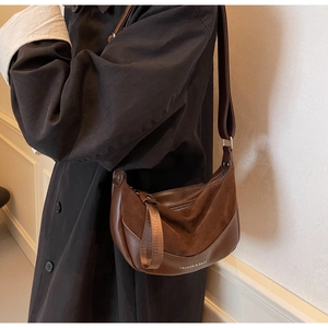 Dettaglio della borsa a mezzaluna in pelle patchwork marrone con texture morbida e stile
