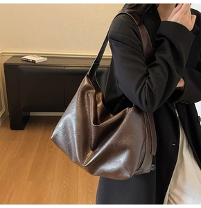 Detail view of large brown vintage tote bag with slouchy hobo texture and wide strap