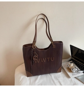 Detailed macro view of retro striped fabric and brown leather trim on the large tote bag