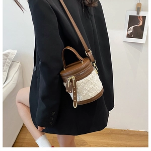Detailaufnahme einer Beuteltasche aus braunem Leder und weißem Teddyfell mit Goldquasten