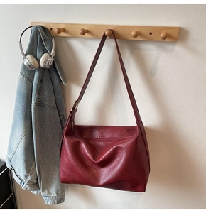 Detailed macro view of the wine red soft leather tote bag with subtle natural texture