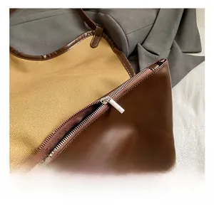 Detail showing the silver metal zipper and premium leather canvas contrast on the tote bag