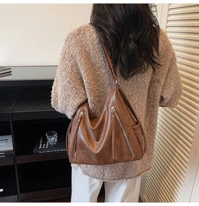 Detail of caramel hobo bag featuring dual zippers and textured soft vegan leather