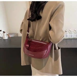 Dettaglio della borsa a luna bordeaux con design patchwork in pelle e camoscio