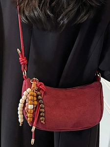Burgundy crescent moon shoulder bag in matte faux suede with colorful wooden bead tassel