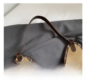 Detail view of khaki canvas tote with brown leather handles and decorative wooden beads