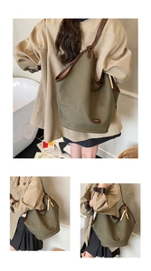 Detail view of the olive canvas tote bag featuring premium leather trim and bead accessory