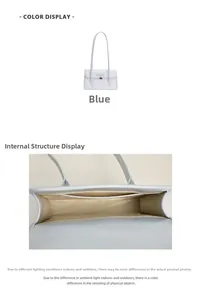 Detail view of the blue underarm bag featuring a metallic heart pendant and spacious interior