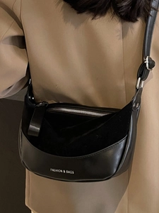 Borsa a tracolla vintage nera in mix di pelle e camoscio su una giacca blazer kaki