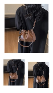 Detail showing brown leather bucket bag with gold chain and colorful bead tassel accessory