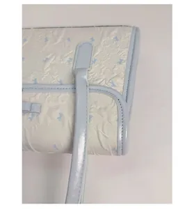 Detail of the reinforced stitching on the blue bow handle attachment for durability