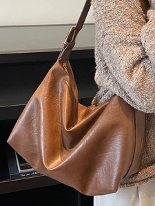 Brown vintage faux leather tote bag with wide shoulder strap for autumn fashion