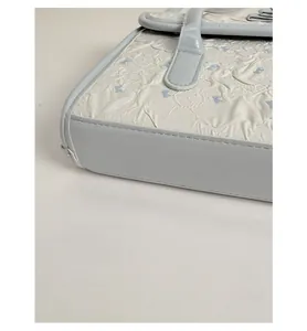 Detailed close-up of reinforced bottom corners and side stitching on blue leather handbag