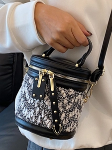 Elegante schwarz-weiße Tweed-Beuteltasche mit Goldakzenten und Ledergriff