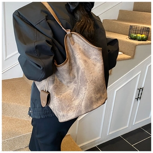 Detail view of large shoulder bag with vintage marble texture worn by a model