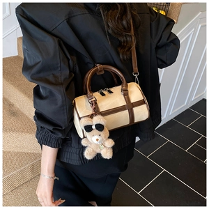 Vista detallada del bolso Boston beige con asas marrones y colgante de oso de peluche
